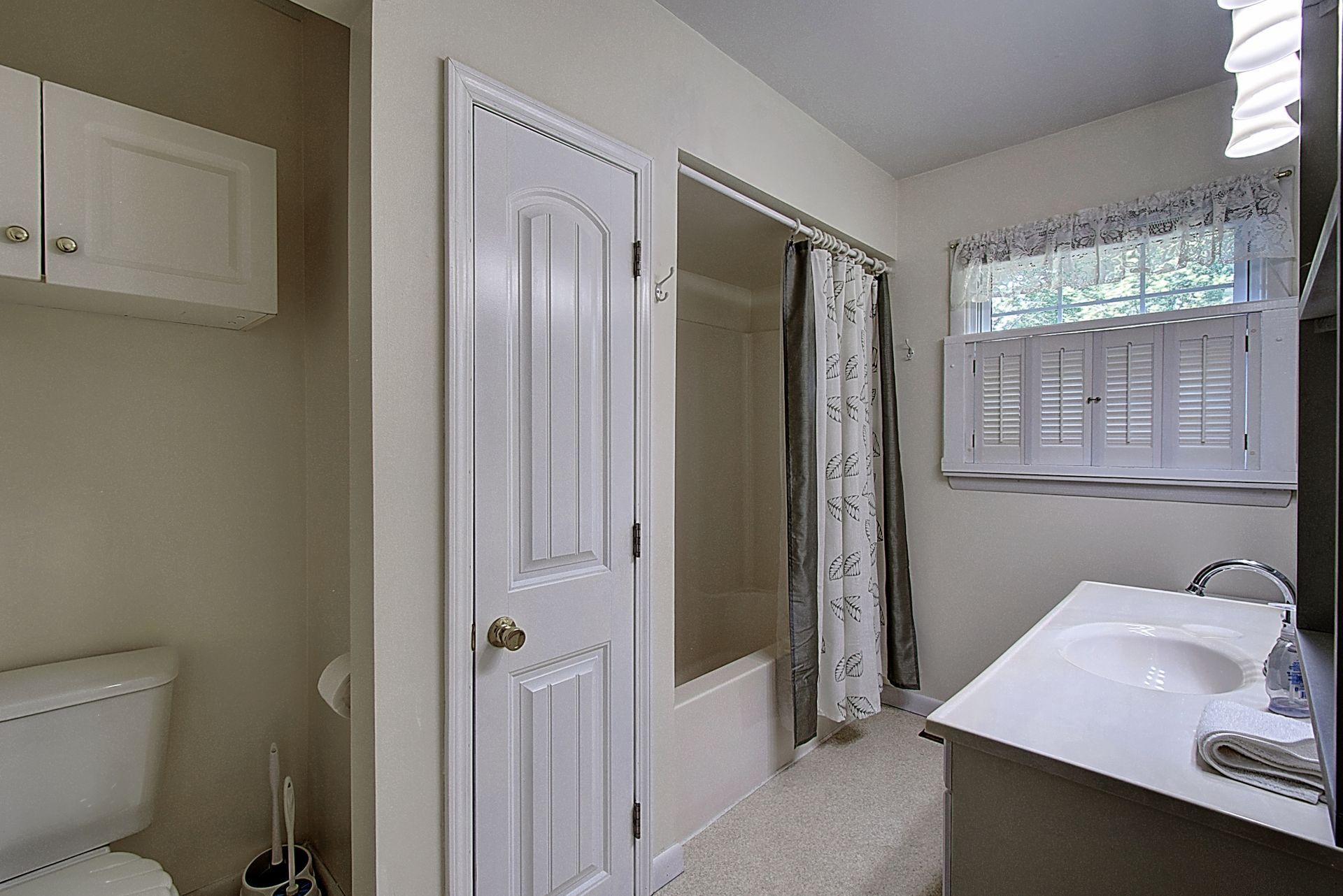 A bathroom with a toilet , sink , and shower.