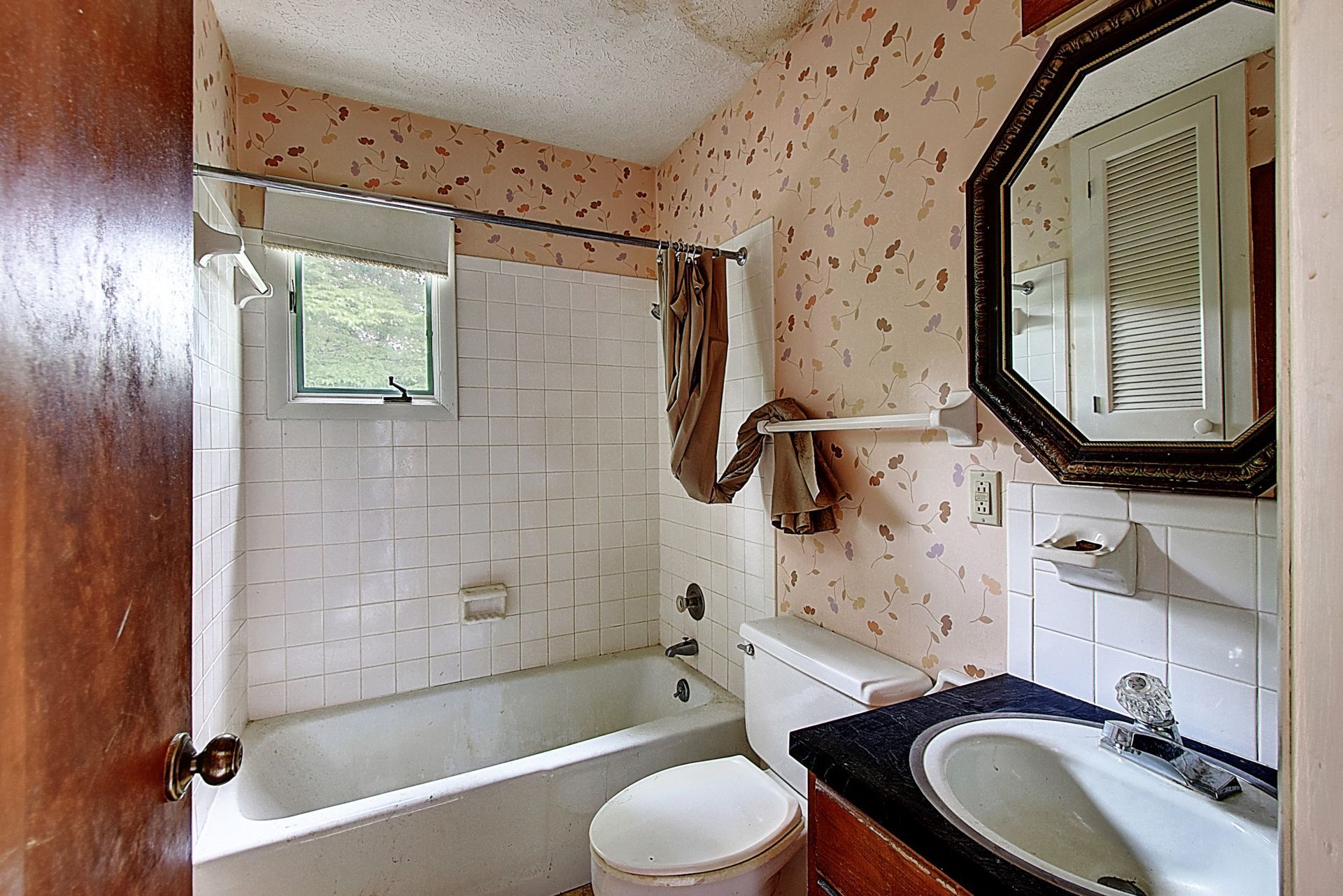 A bathroom with a toilet a sink and a mirror