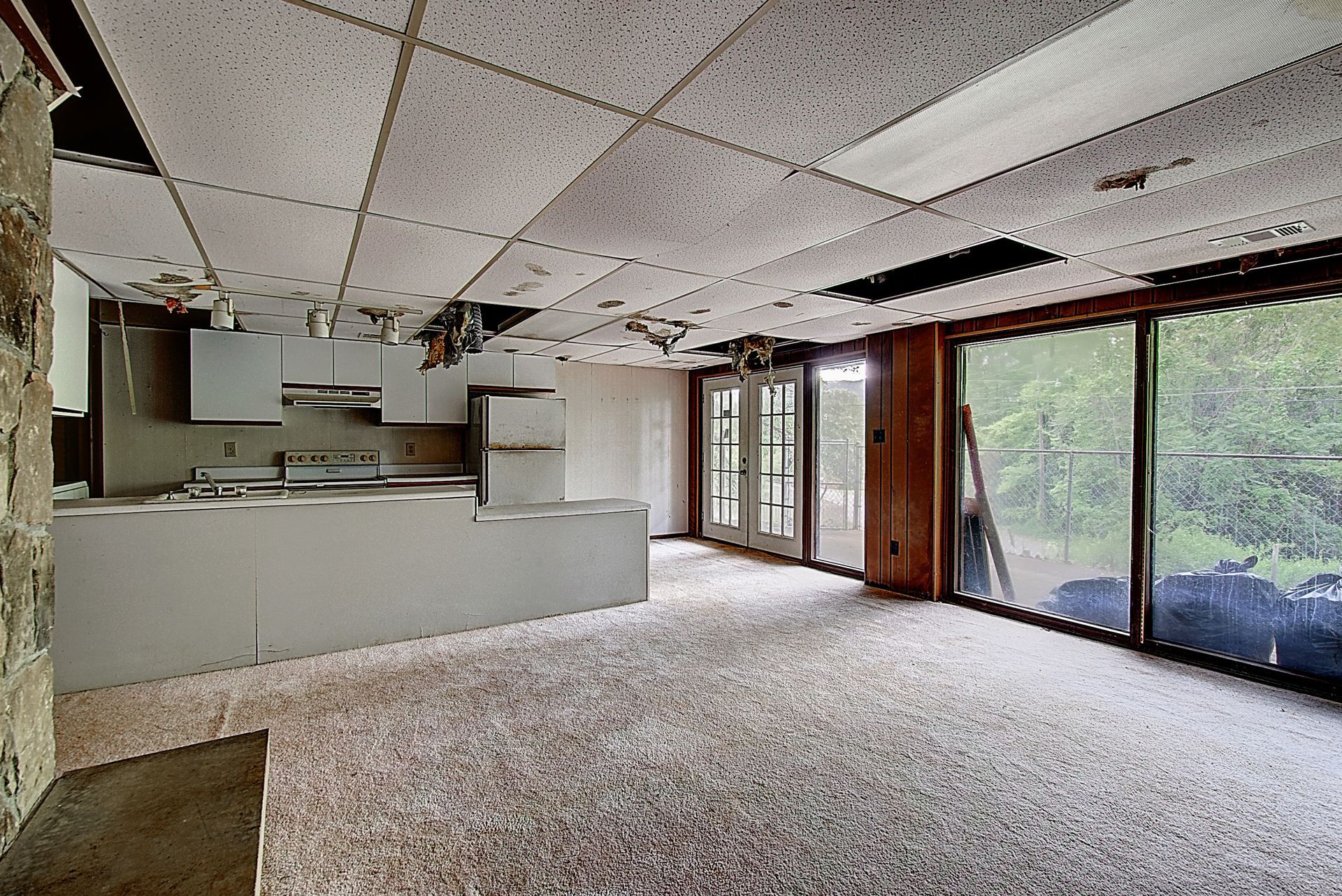 An empty room with a kitchen and sliding glass doors