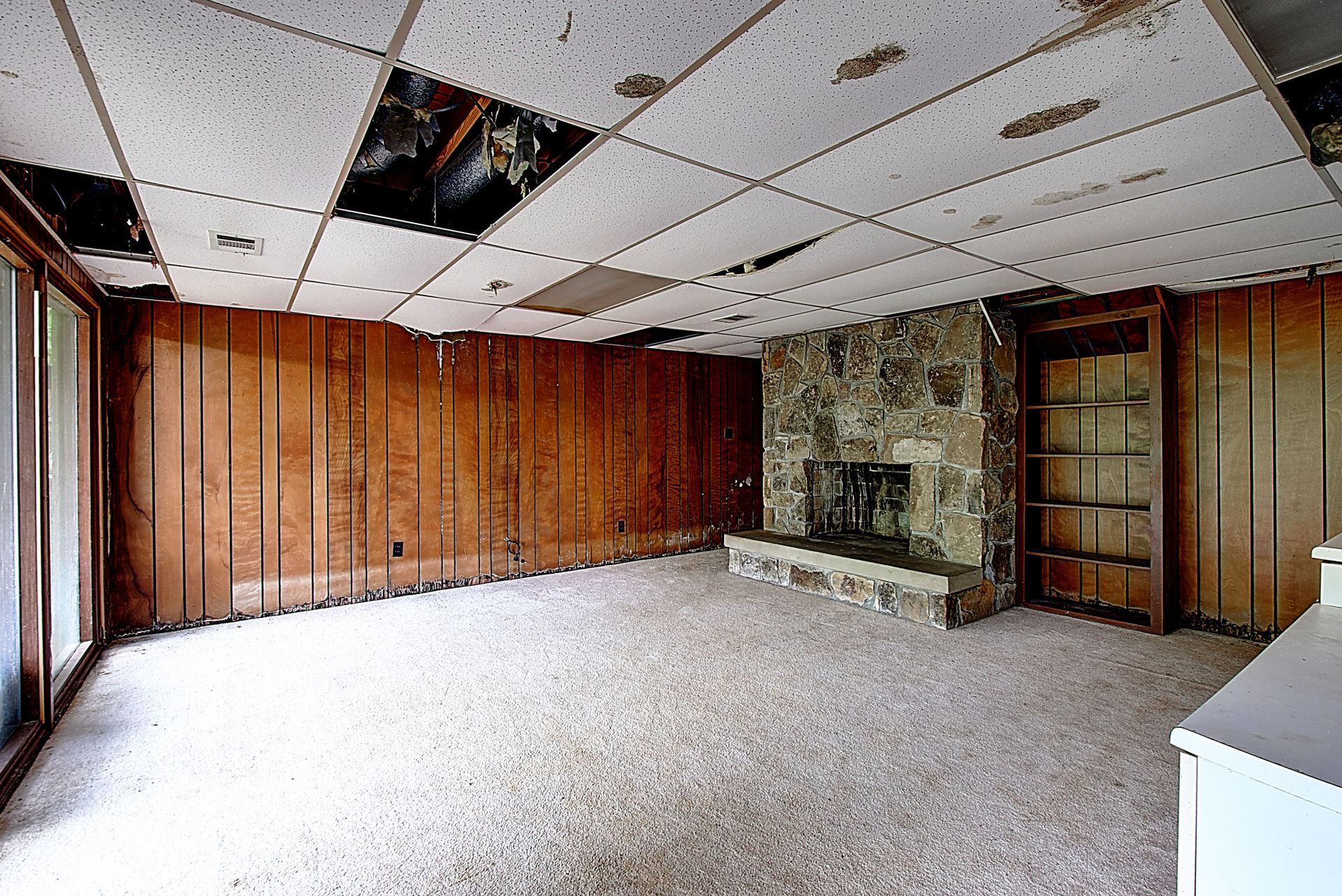 An empty room with wood paneling and a fireplace