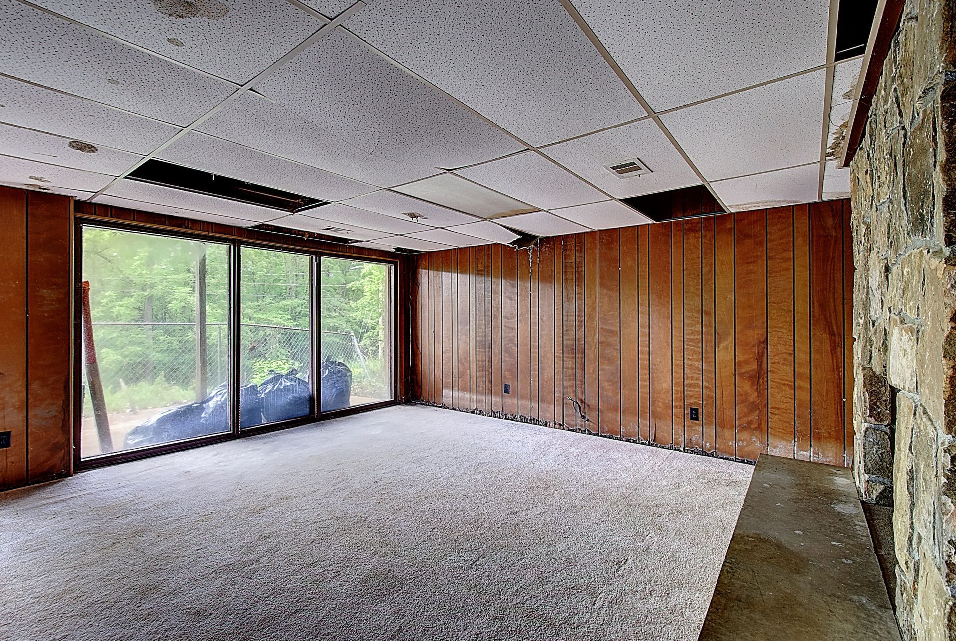 An empty room with a lot of windows and wood paneling.