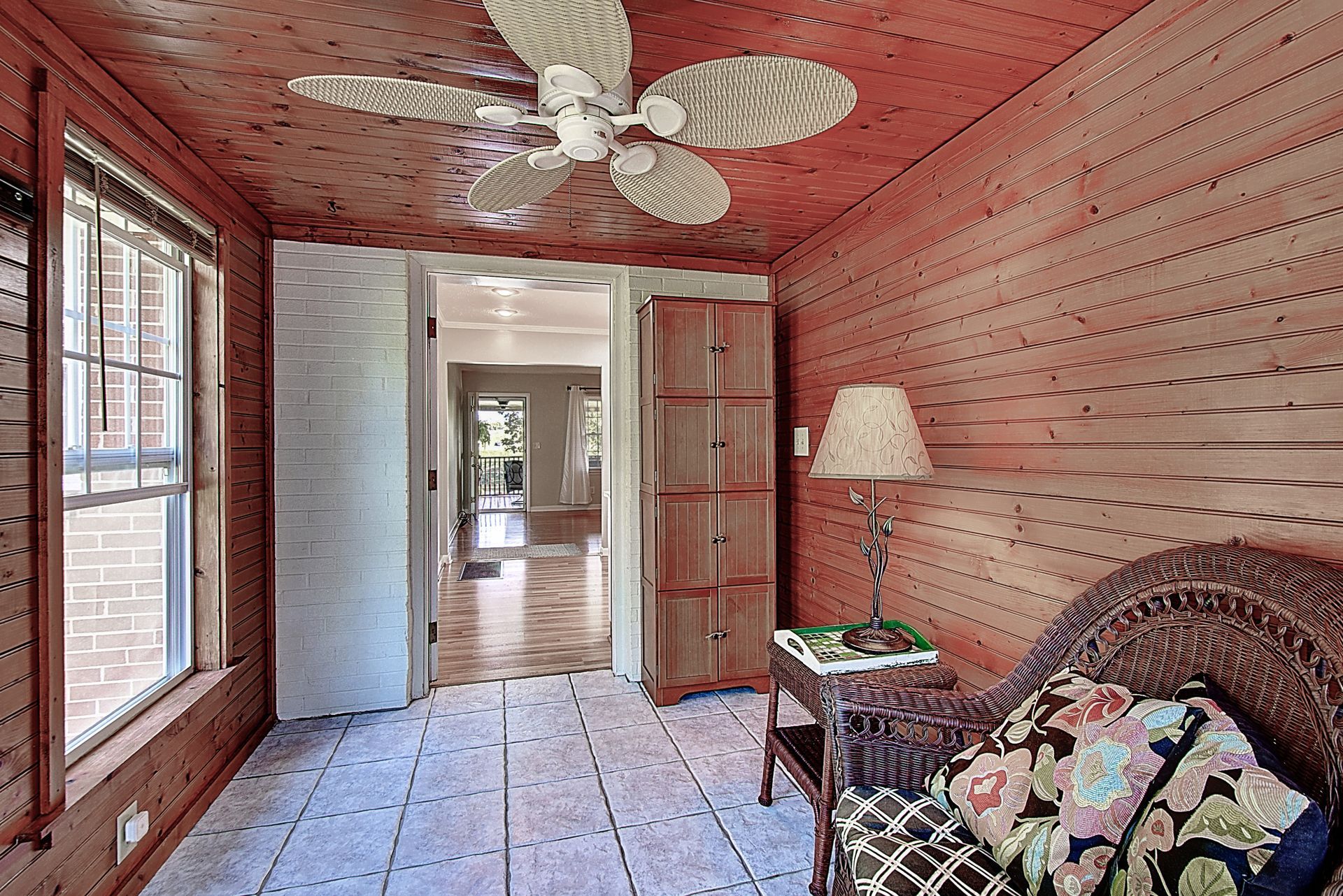 A living room with a ceiling fan and a chair