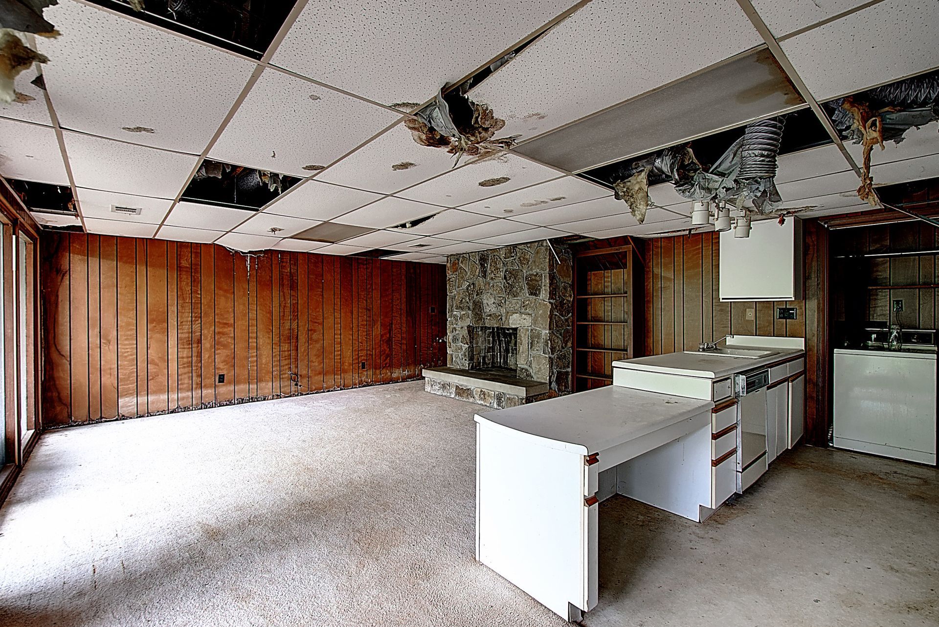 An empty room with a kitchen and a fireplace