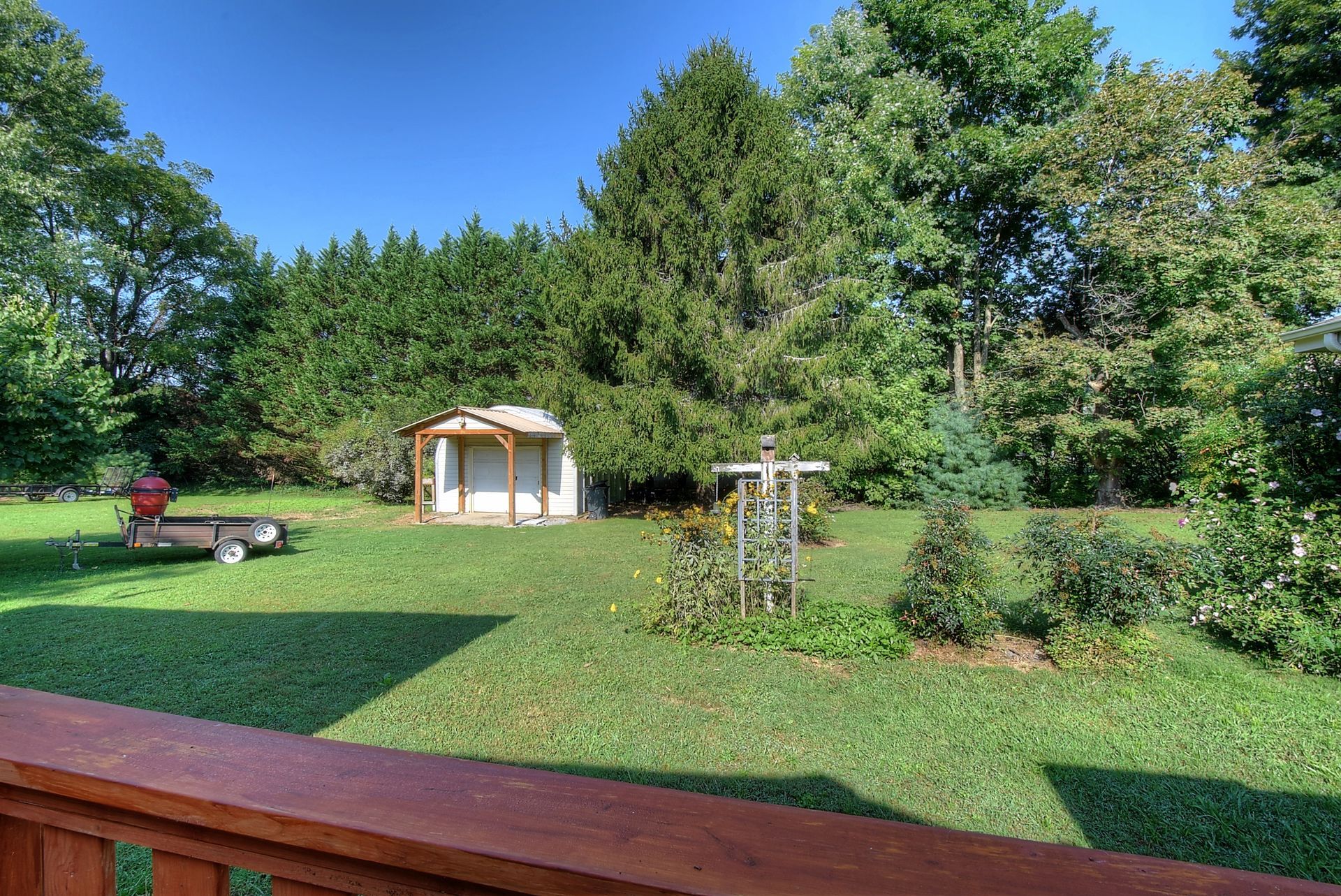 A view of a backyard from a deck with a shed in the background