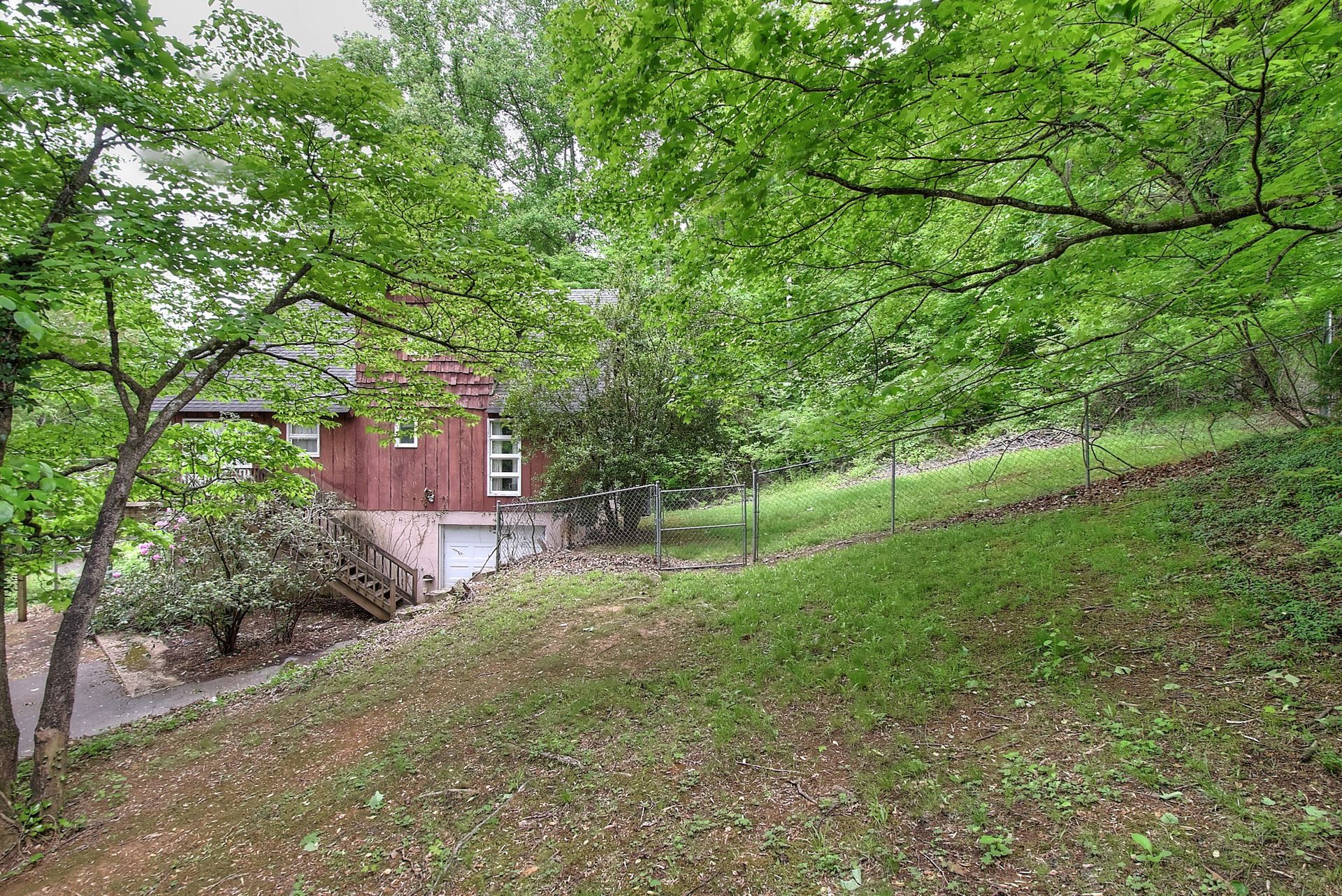 A small house is sitting on top of a hill surrounded by trees.