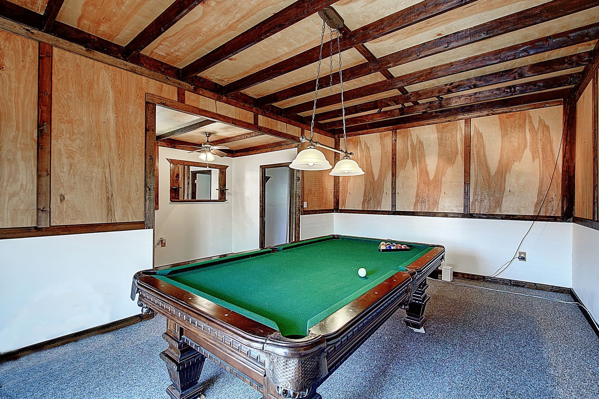 A pool table in a room with a wooden ceiling