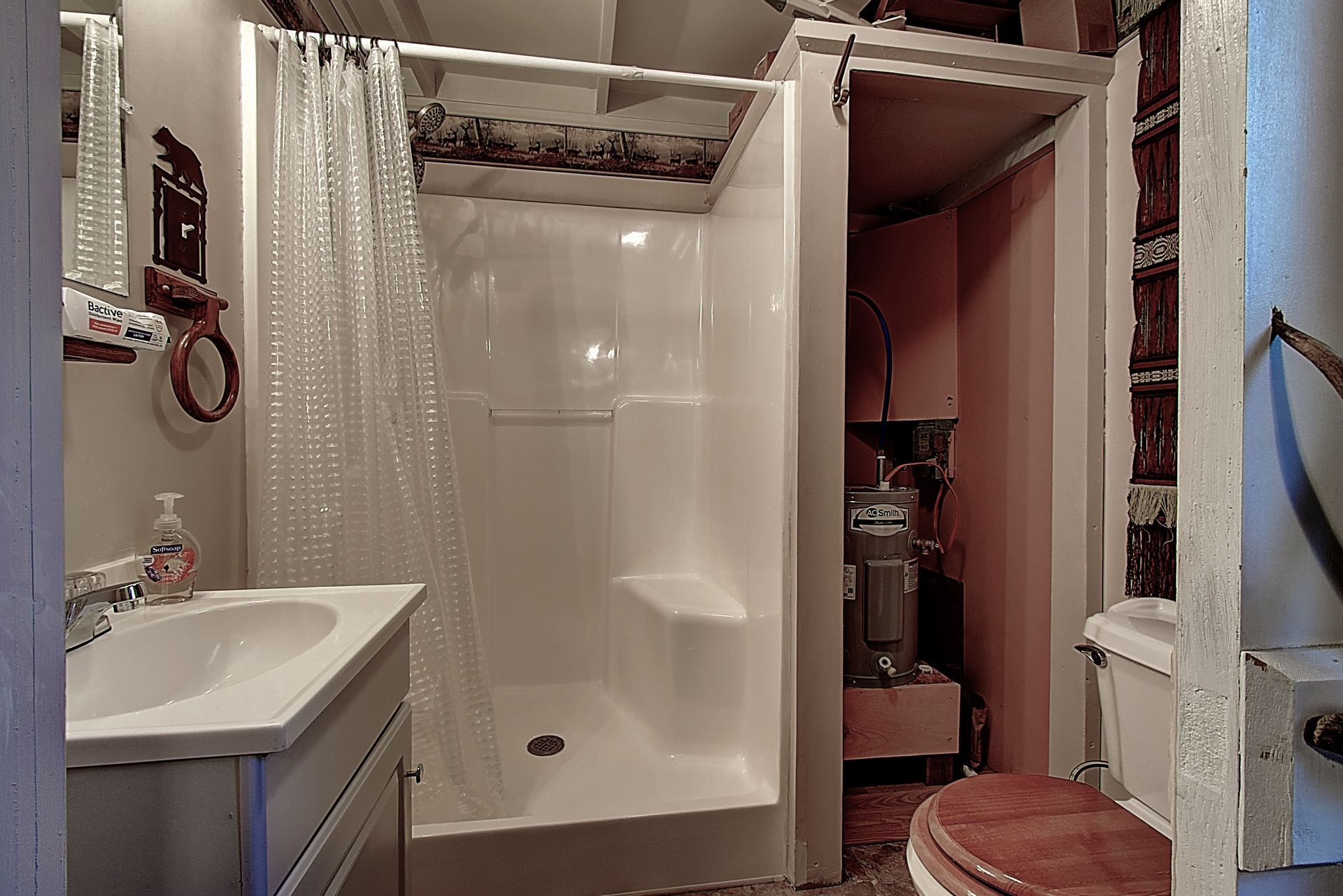 A bathroom with a toilet , sink and shower.