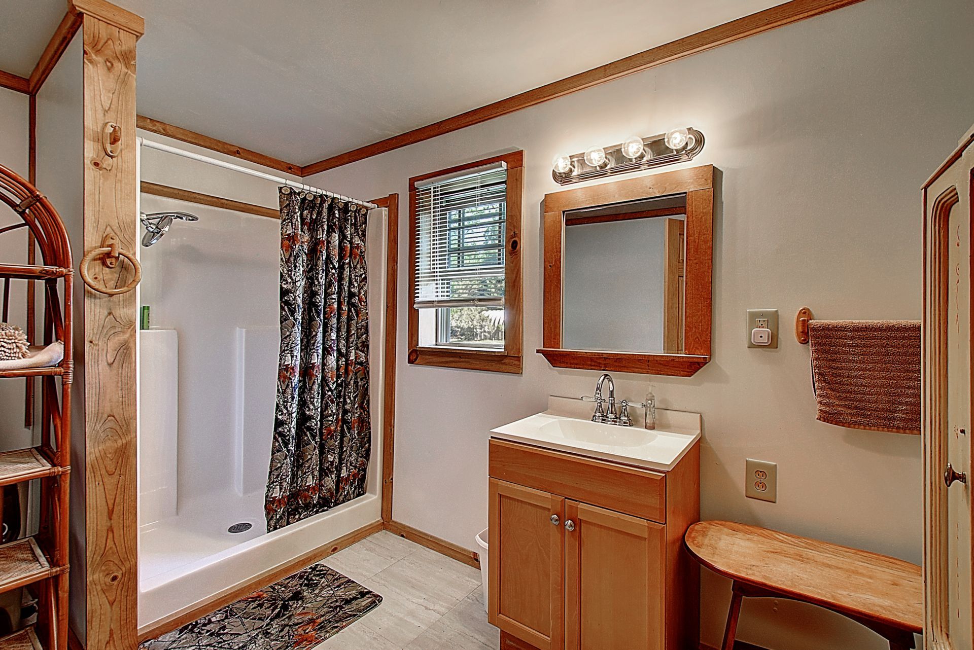A bathroom with a sink , mirror and shower.