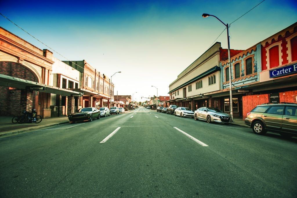 A row of cars are parked on the side of a street in a downtown Elizabethton Tennessee