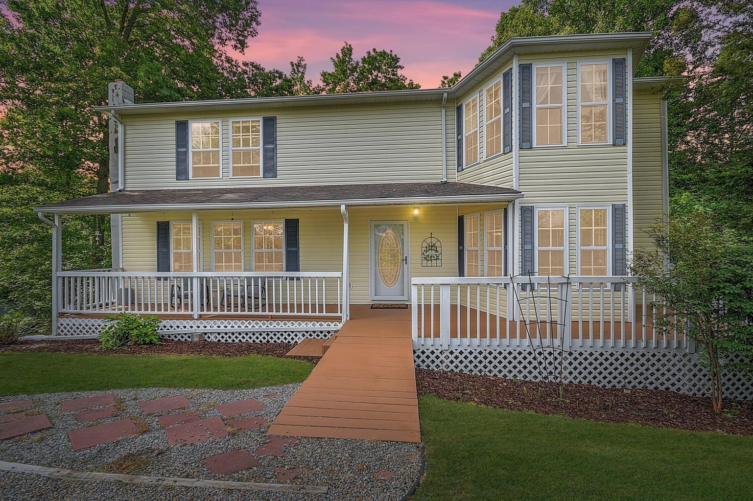 A house with a large porch and a walkway leading to it