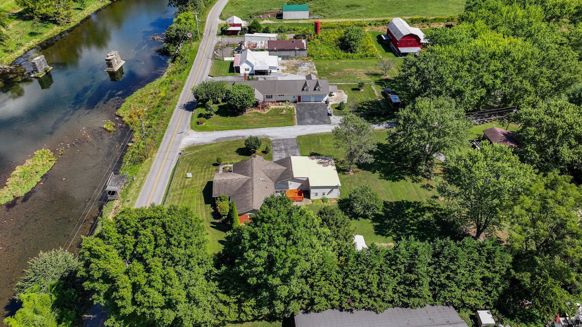 An aerial view of a house surrounded by trees and a river at 238 Wilbur Dam Rd Elizabethton Tennessee.