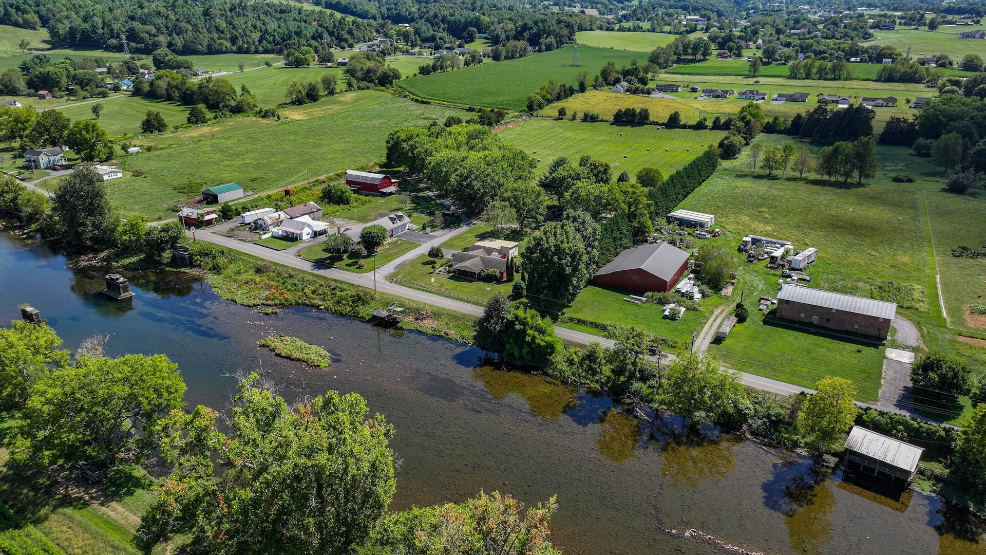 An aerial view of a river surrounded by fields and houses at 238 Wilbur Dam Rd Elizabethton Tennessee.