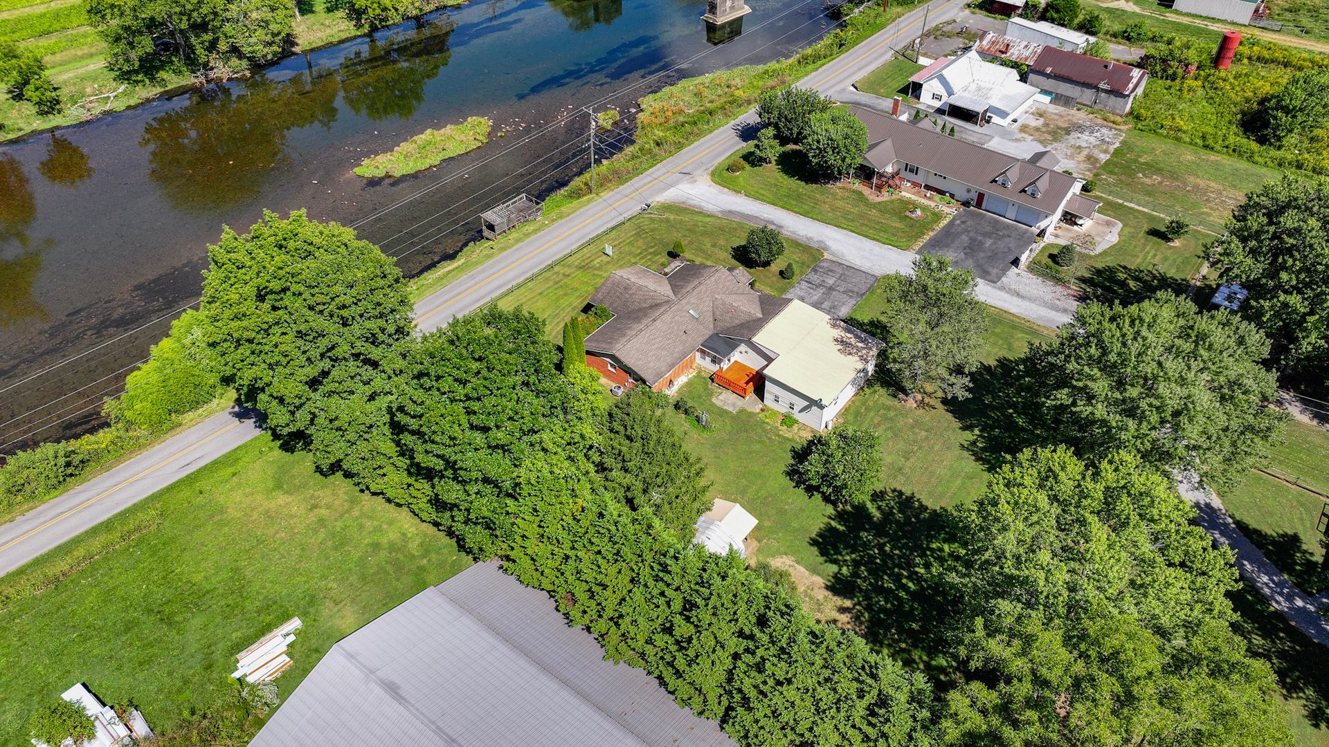 An aerial view of a house next to a river in a residential area at 238 Wilbur Dam Rd Elizabethton Tennessee.