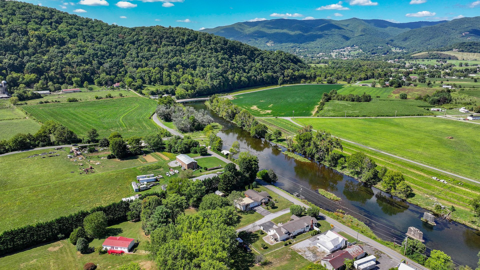 An aerial view of a river surrounded by mountains and fields at 238 Wilbur Dam Rd Elizabethton Tennessee