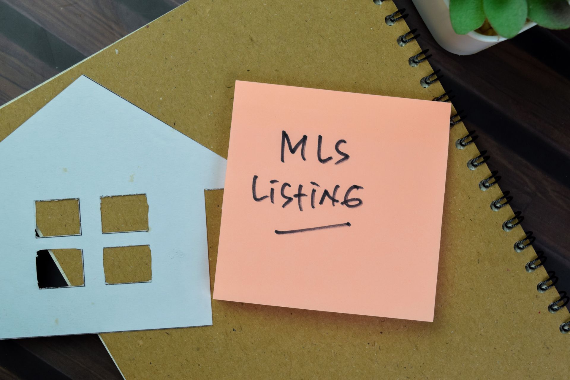 Paper House and sticky note reading MLS Listing