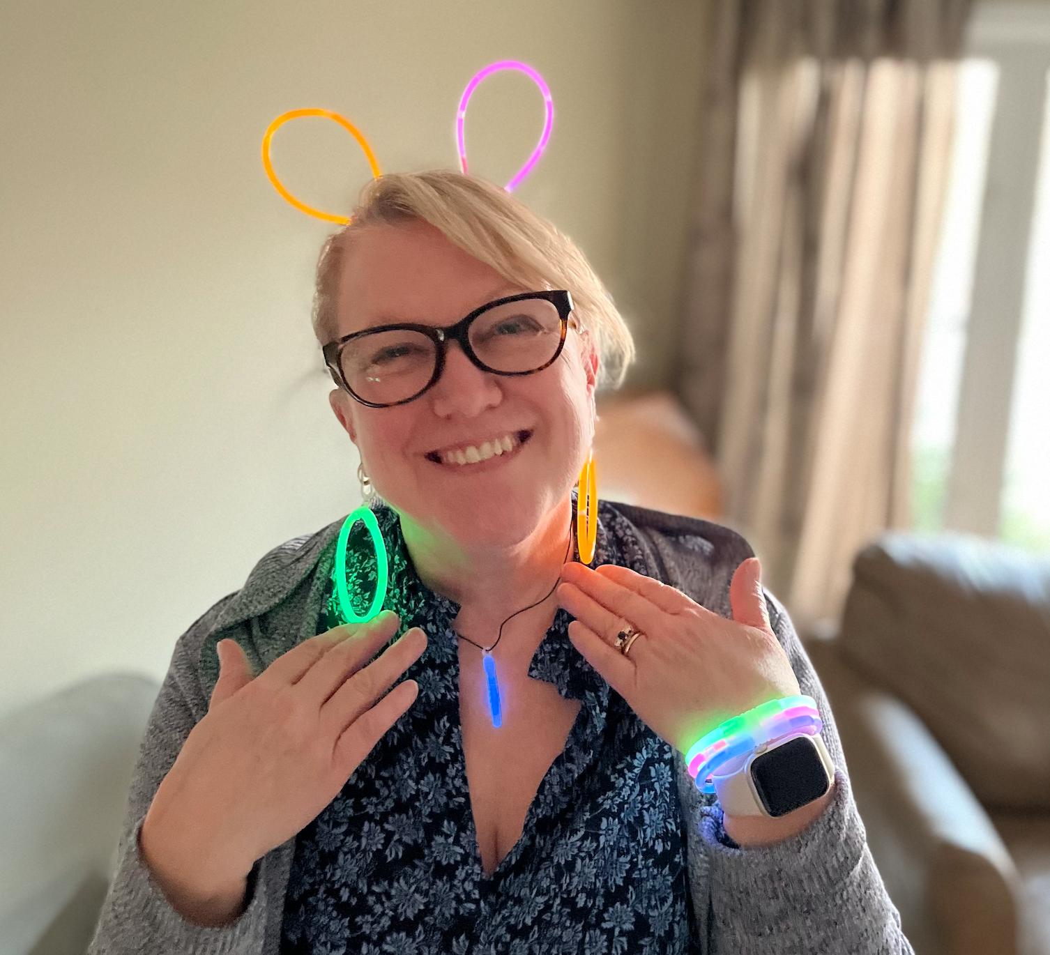 The woman owner of Twisted Stitch wearing glasses and glow in the dark bracelets