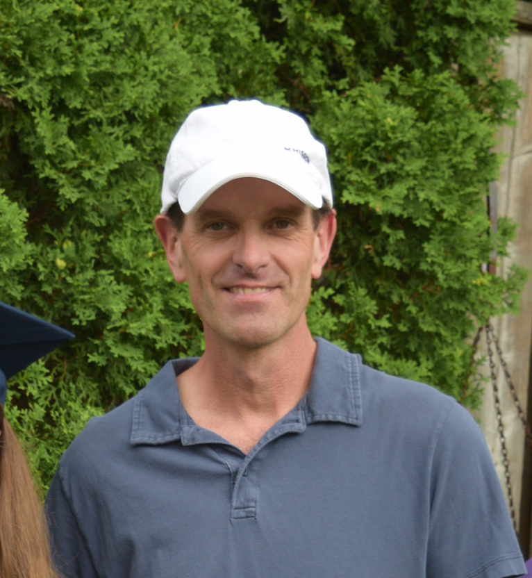 A man wearing a white hat and a blue shirt