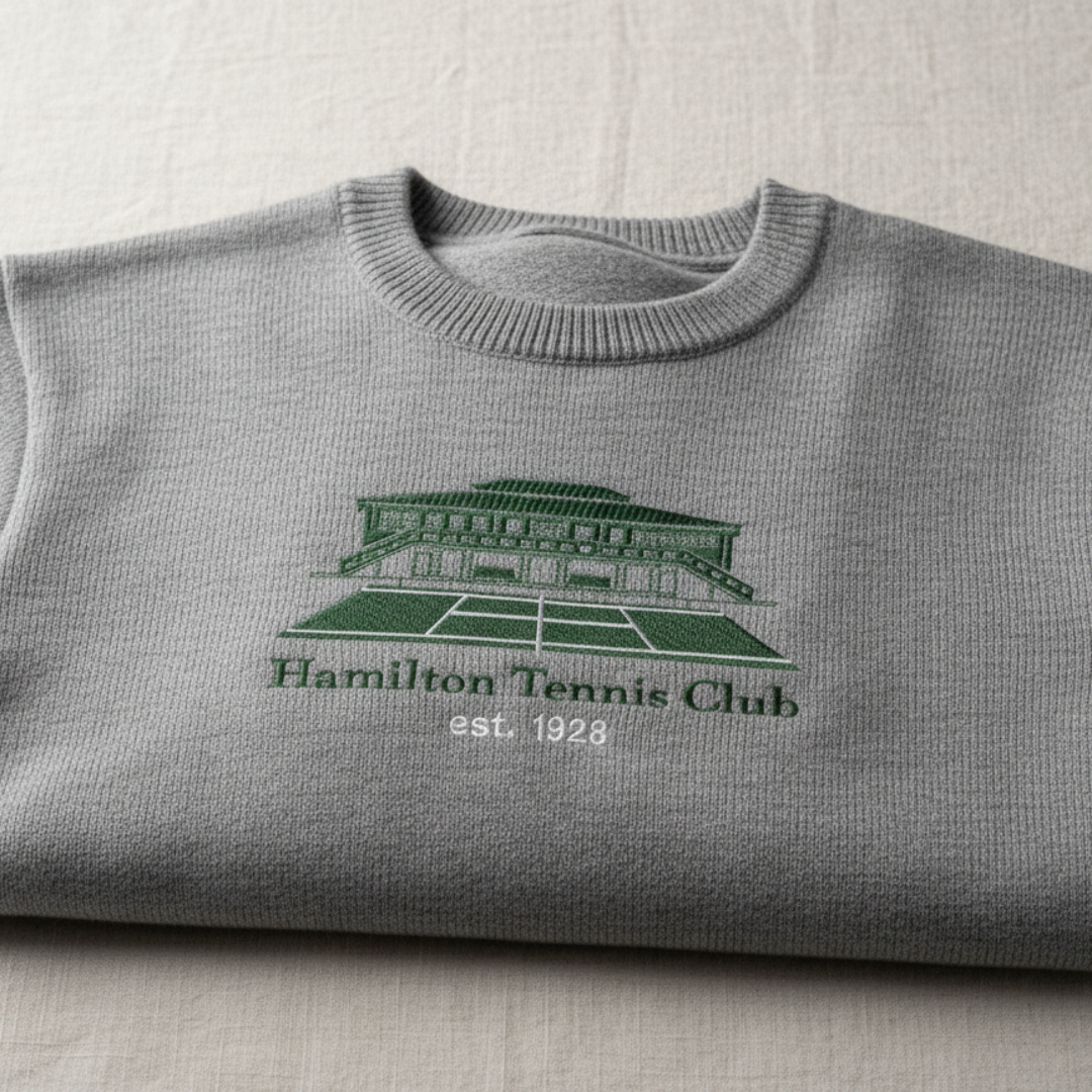 Gray sweater with embroidered green Hamilton Tennis Club logo and tennis court.