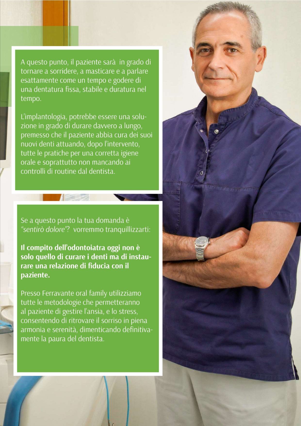 Un uomo con una camicia blu è in piedi con le braccia incrociate.