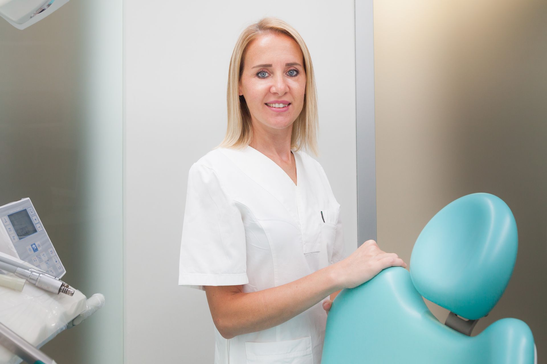 Una donna è in piedi in uno studio dentistico davanti a un apparecchio odontoiatrico.