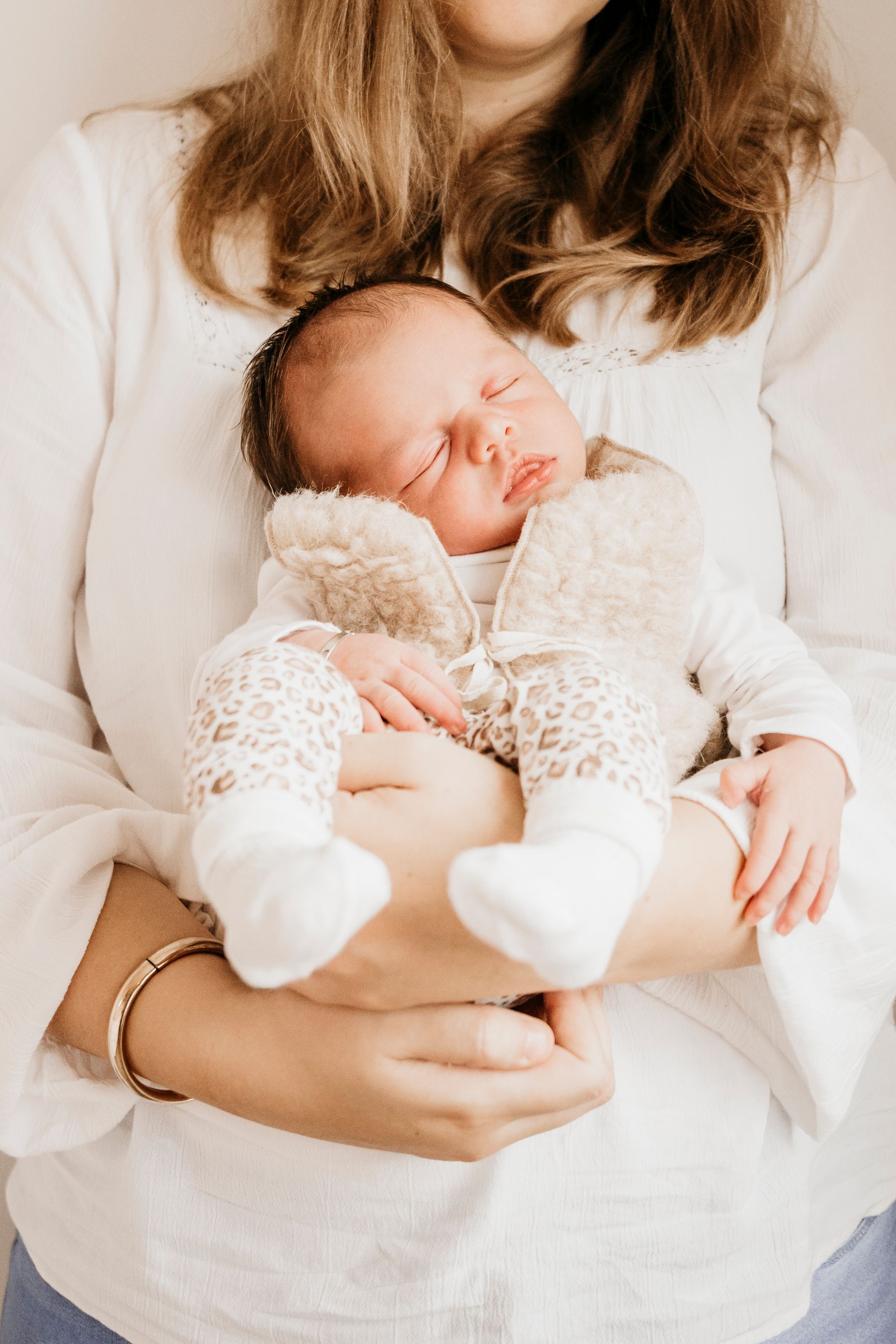 Een vrouw houdt een pasgeboren baby in haar armen.