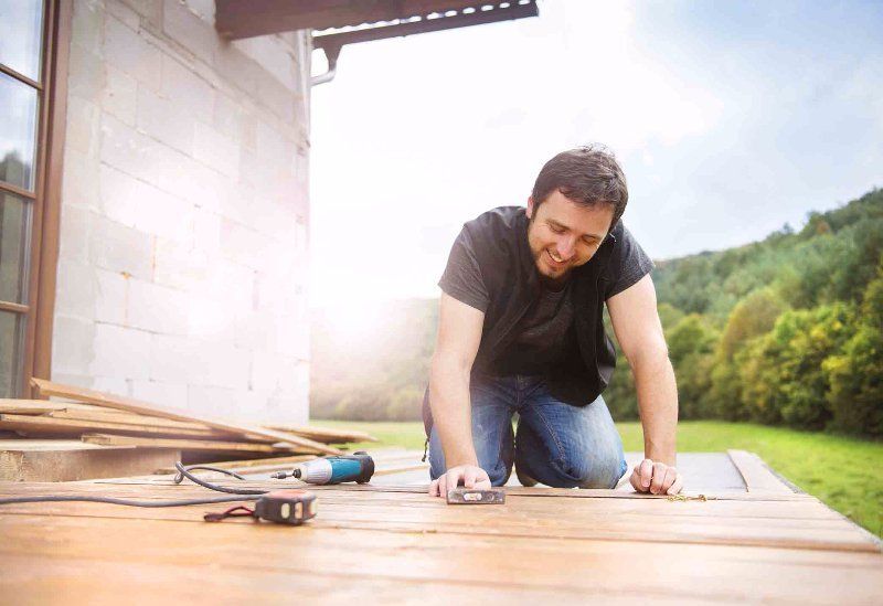 man working on a wooden porch