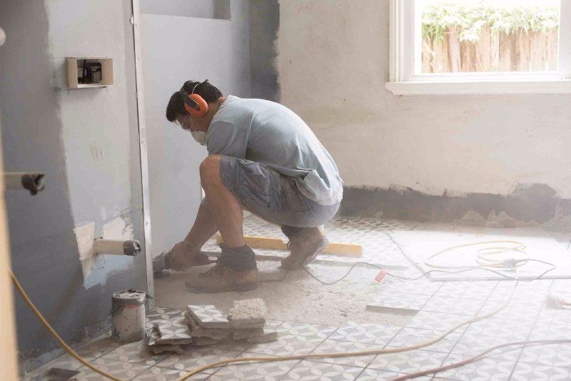 man working on a tile floor