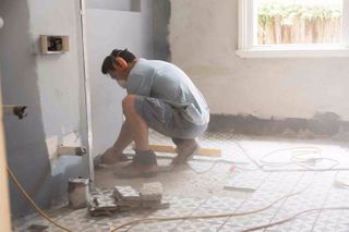 man working on a tile floor