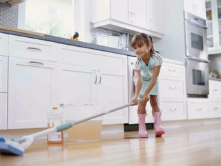 young girl cleaning a wooden floor