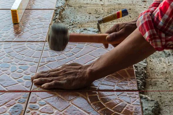 hammering a stone tile floor