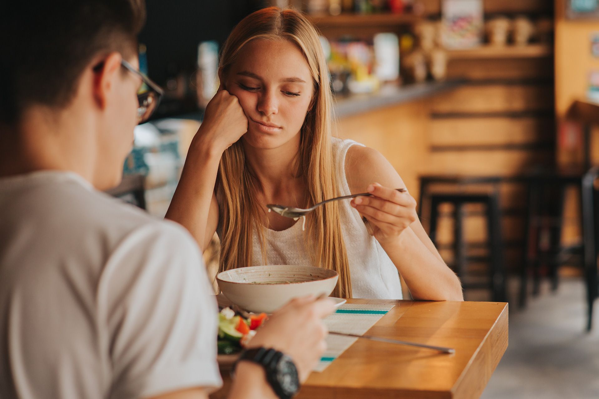 A man and a woman are sitting at a table eating food.