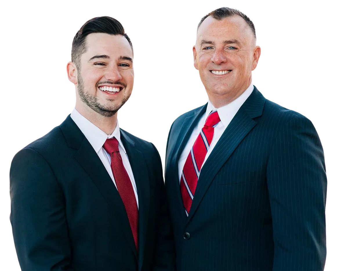 Two men in suits smiling, red ties, against a plain background.