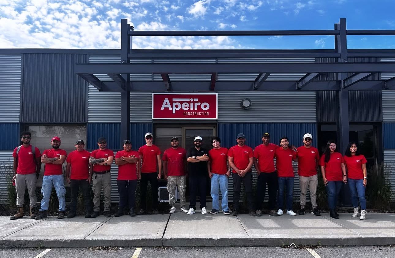 Group of employees in red shirts standing outside an Apetito building entrance.