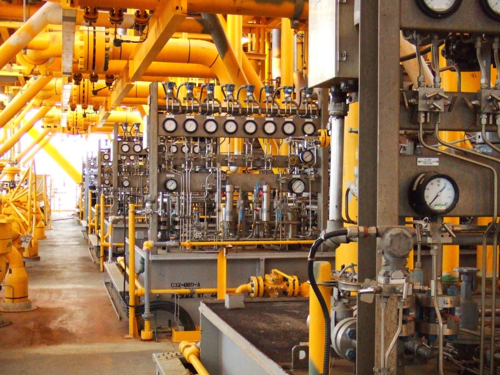 A large room with lots of yellow pipes and gauges
