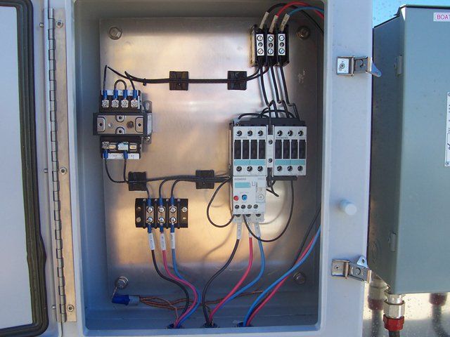 The inside of an electrical box with many wires connected to it