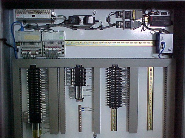 A control panel with a lot of wires coming out of it