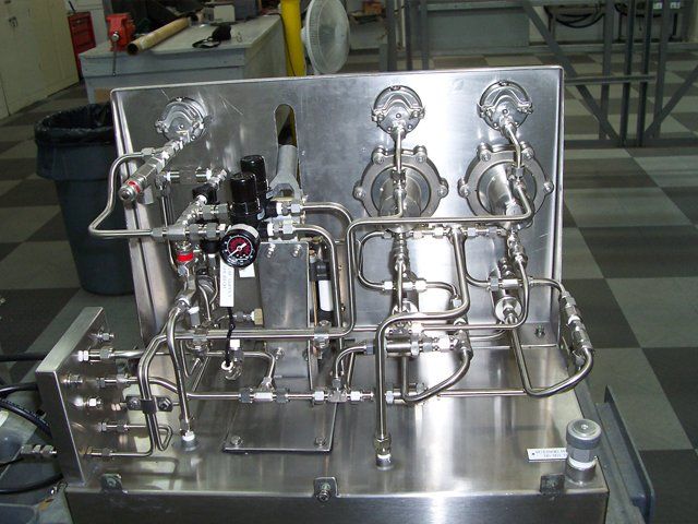 A stainless steel machine with lots of pipes and valves