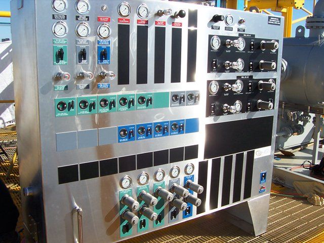 A stainless steel control panel with a lot of buttons and knobs