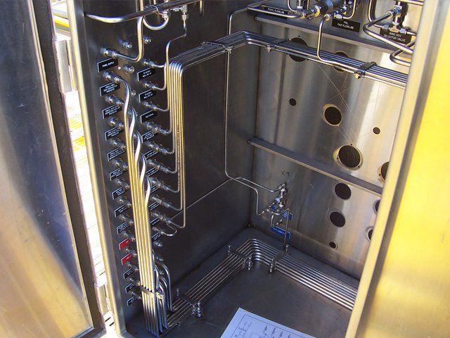 A stainless steel cabinet with a bunch of pipes in it