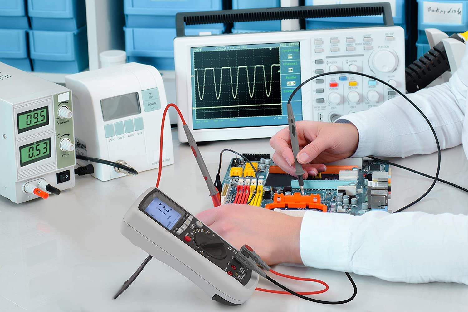 A person is working on a circuit board with a multimeter.
