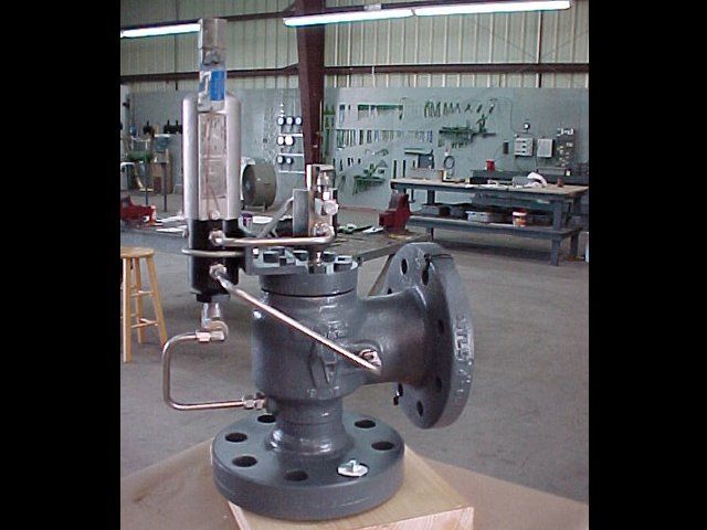 A gray valve is sitting on top of a wooden box in a room.