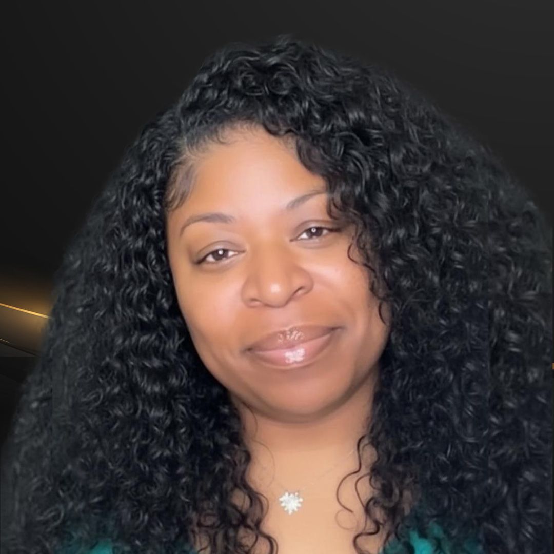 Woman with curly black hair, wearing teal top, smiling at the camera.