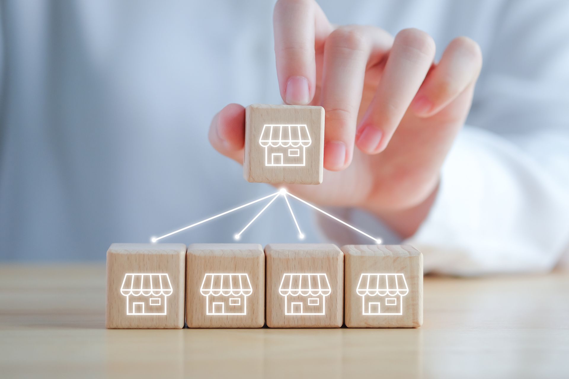Hand placing franchise icon block over other franchise blocks.