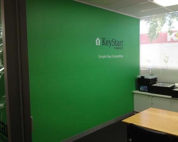green wall with key start logo