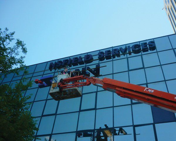 sign installation on glass building