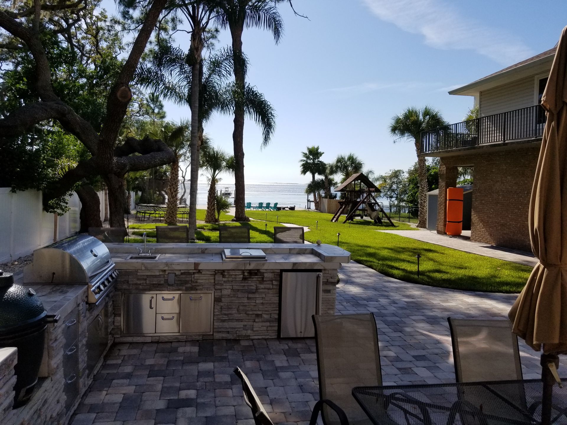 A patio with a table and chairs and a grill
