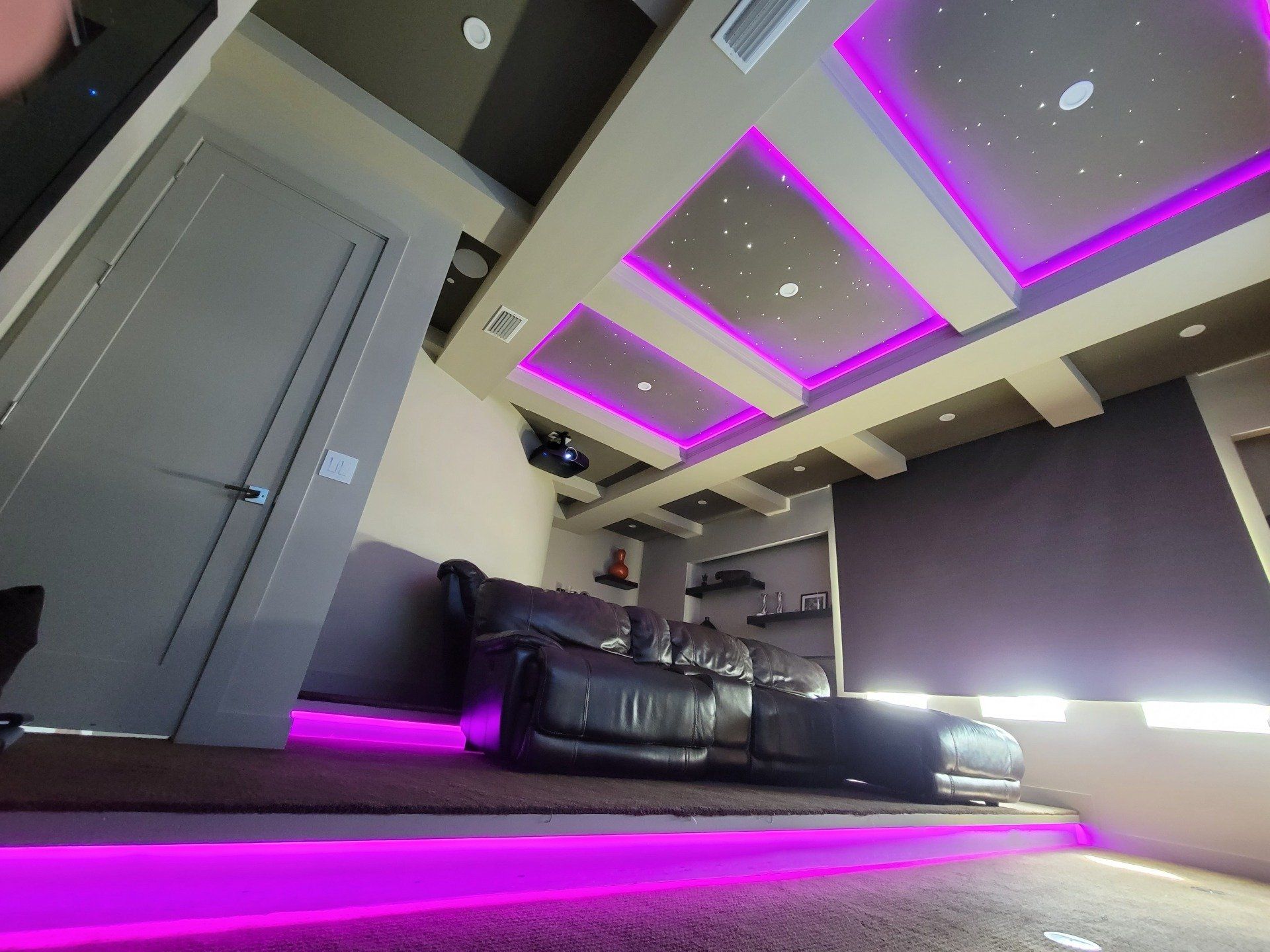 A living room with purple lights on the ceiling