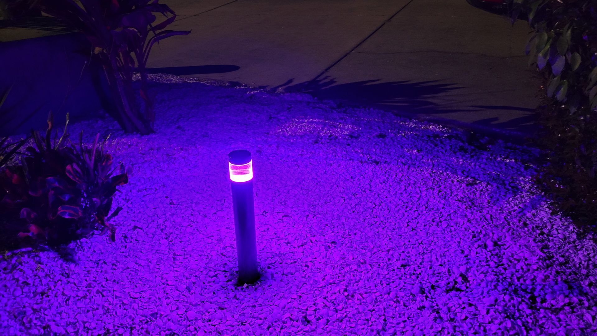 A purple light is sitting on top of a pile of gravel.