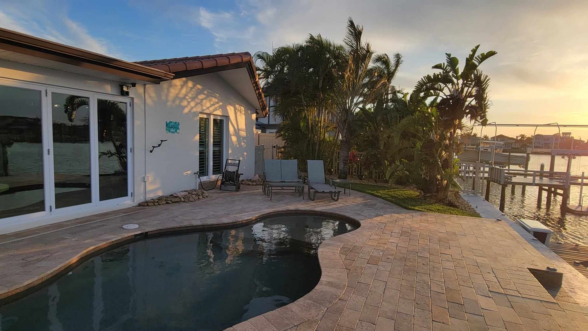 There is a large swimming pool in front of a house.
