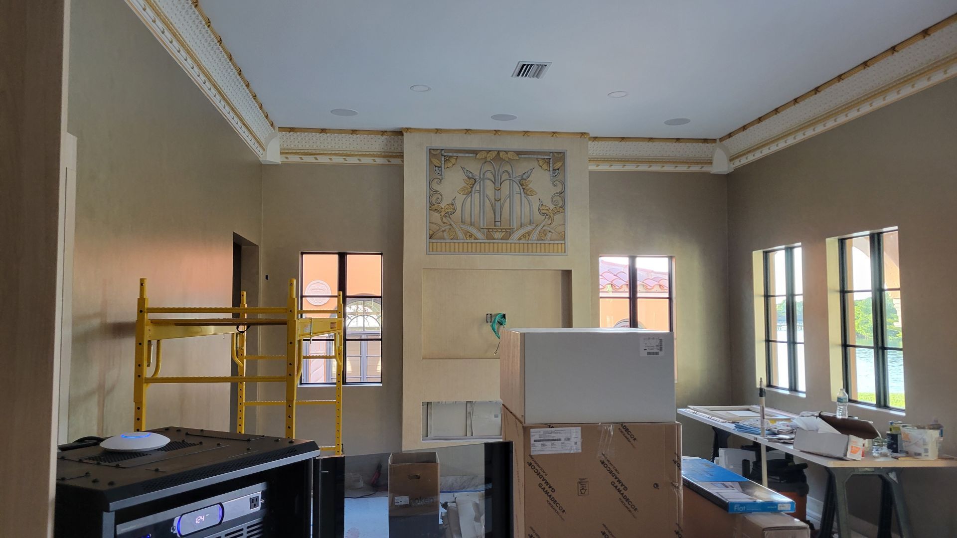 A large room with a fireplace and scaffolding in it.